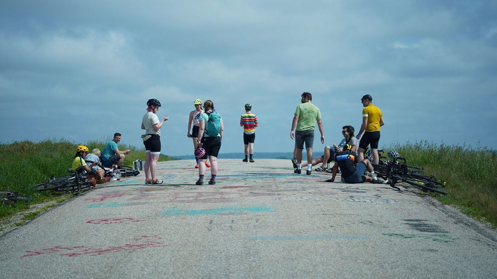 A group of people are standing on the side of a road.