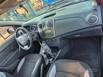Mercedes-Benz decappottabile color argento parcheggiata in strada. L'auto ha la parte inferiore della carrozzeria grigio scuro e la capote nera.