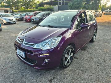 Una Citroen C3 viola parcheggiata all'aperto in una giornata di sole, circondata da altre auto.