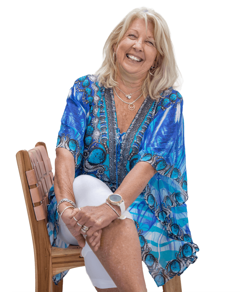 A woman is sitting on a chair with her legs crossed and smiling.