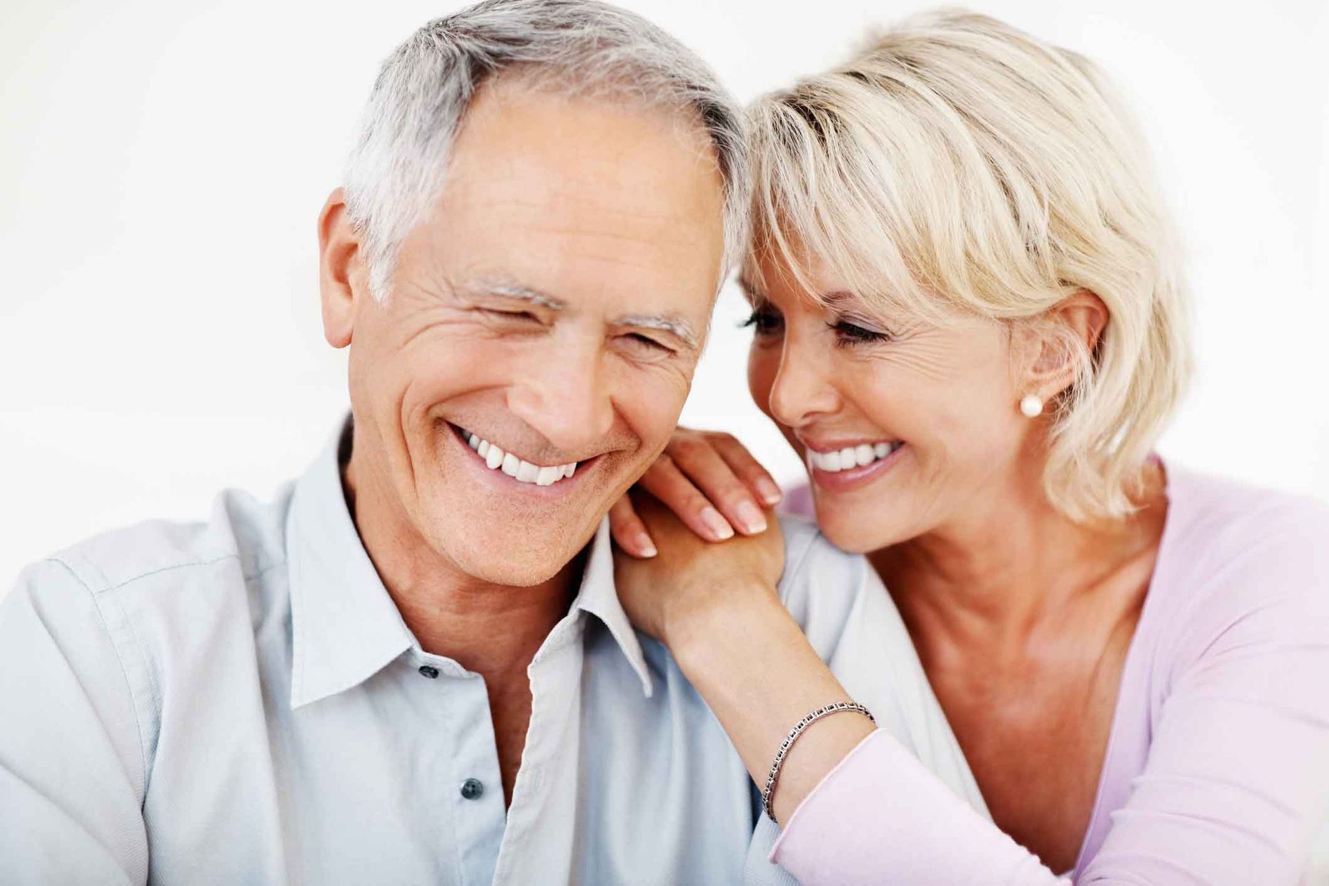 A man and a woman are smiling and holding hands