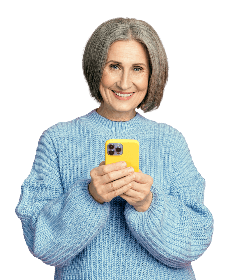 An elderly woman in a blue sweater is holding a yellow cell phone.