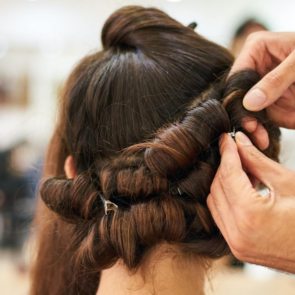 A woman is getting her hair done by a hairdresser.