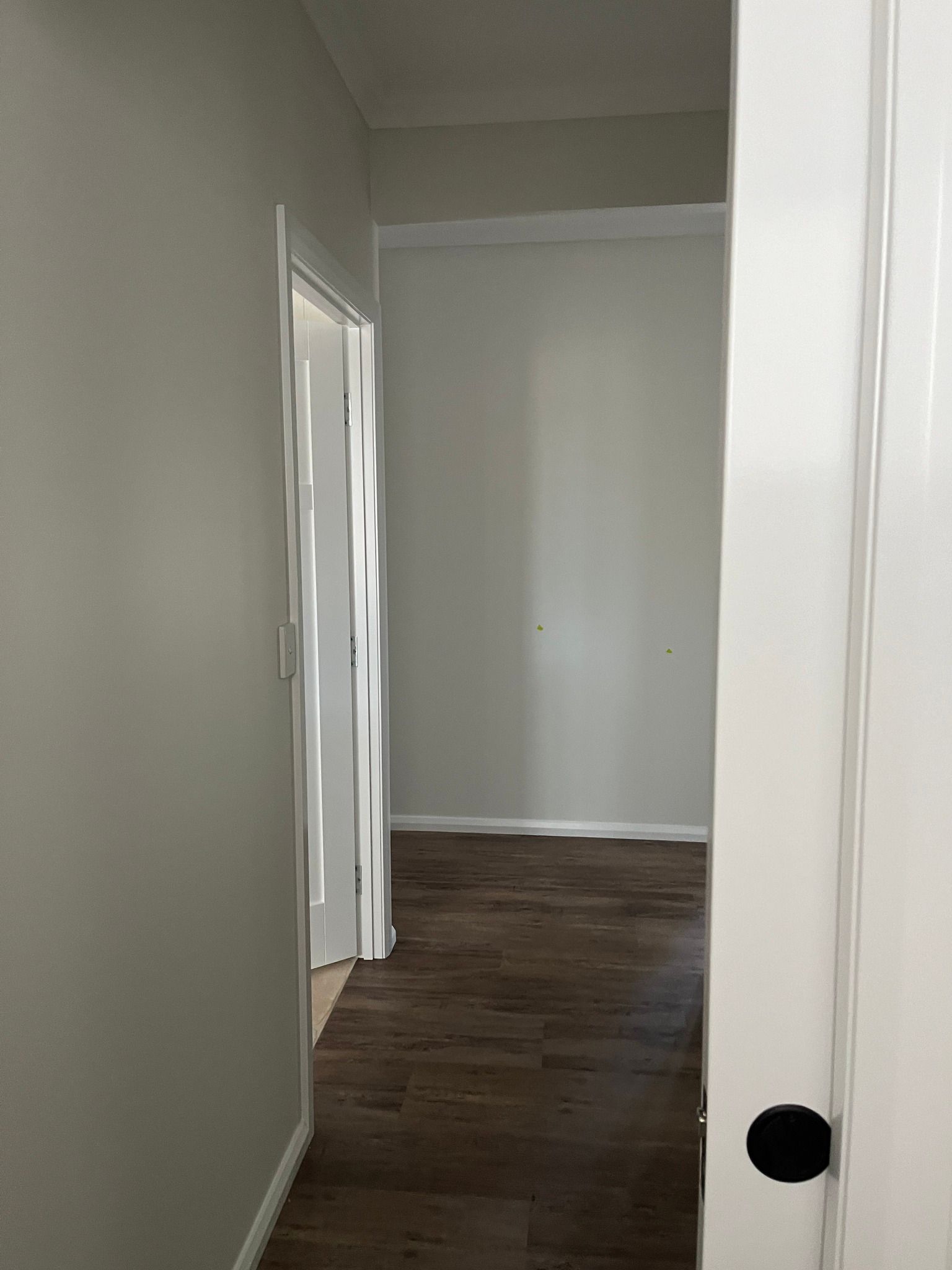 A View Through a Door Frame Into a Hallway With Grey Walls — Priority Painters in Gladstone Central, QLD