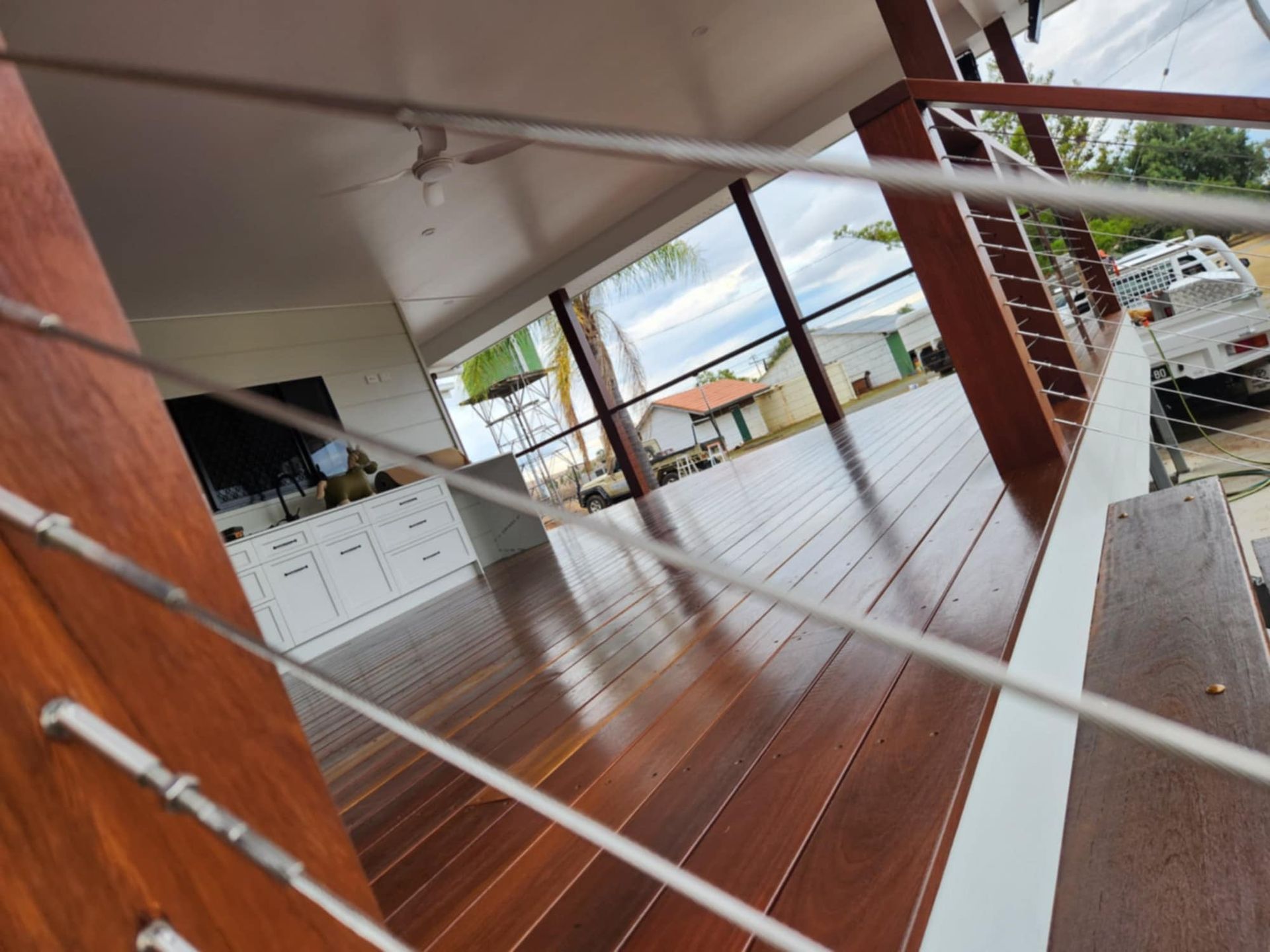 A Wooden Deck With Cable Railing — Priority Painters in Gladstone Central, QLD