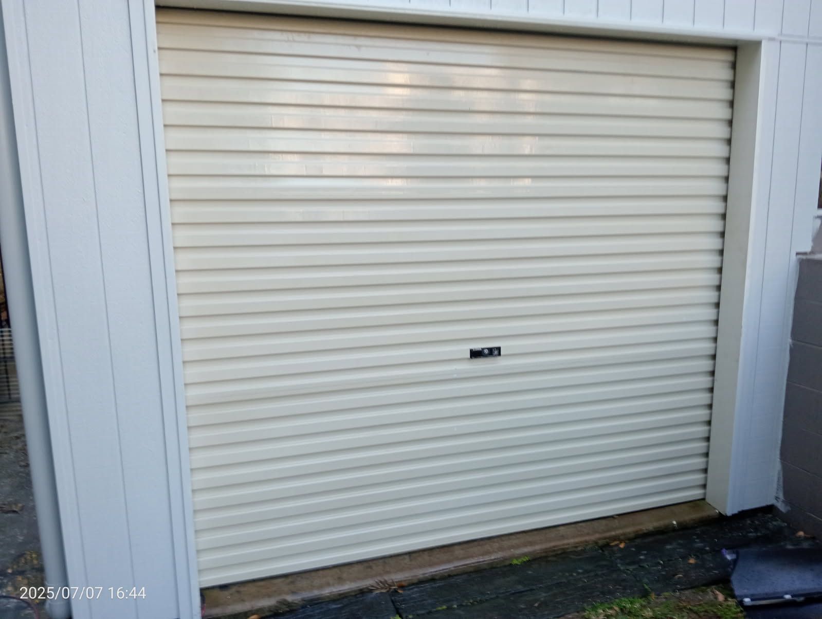 A Cream-colored, Horizontal Slatted Roller Garage Door — Priority Painters in Gladstone Central, QLD