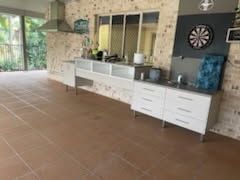 An Outdoor Kitchen Area With White Cabinetry — Priority Painters in Gladstone Central, QLD