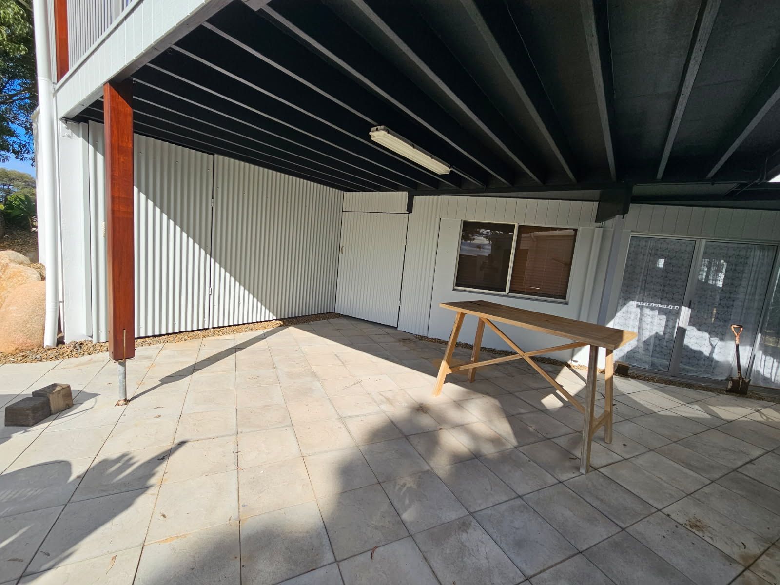 A Covered Outdoor Patio With Light-colored Floor Tiles — Priority Painters in Gladstone Central, QLD
