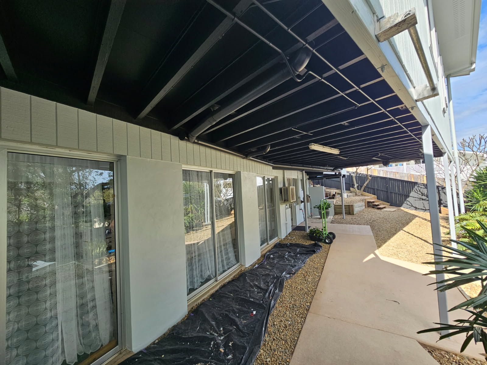A Low-angle View of a House Exterior With Glass Sliding Doors — Priority Painters in Gladstone Central, QLD