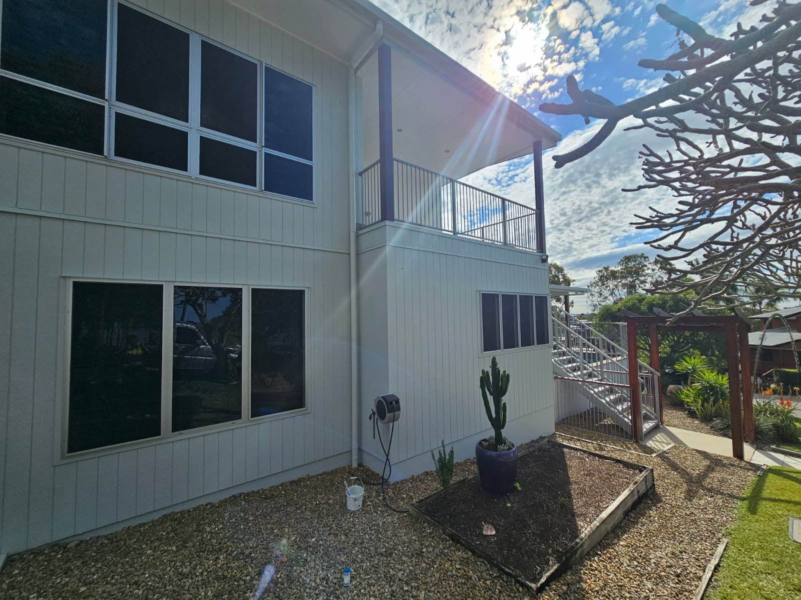 A Two-story White House With Dark Tinted Windows and a Small Outdoor Balcony — Priority Painters in Gladstone Central, QLD