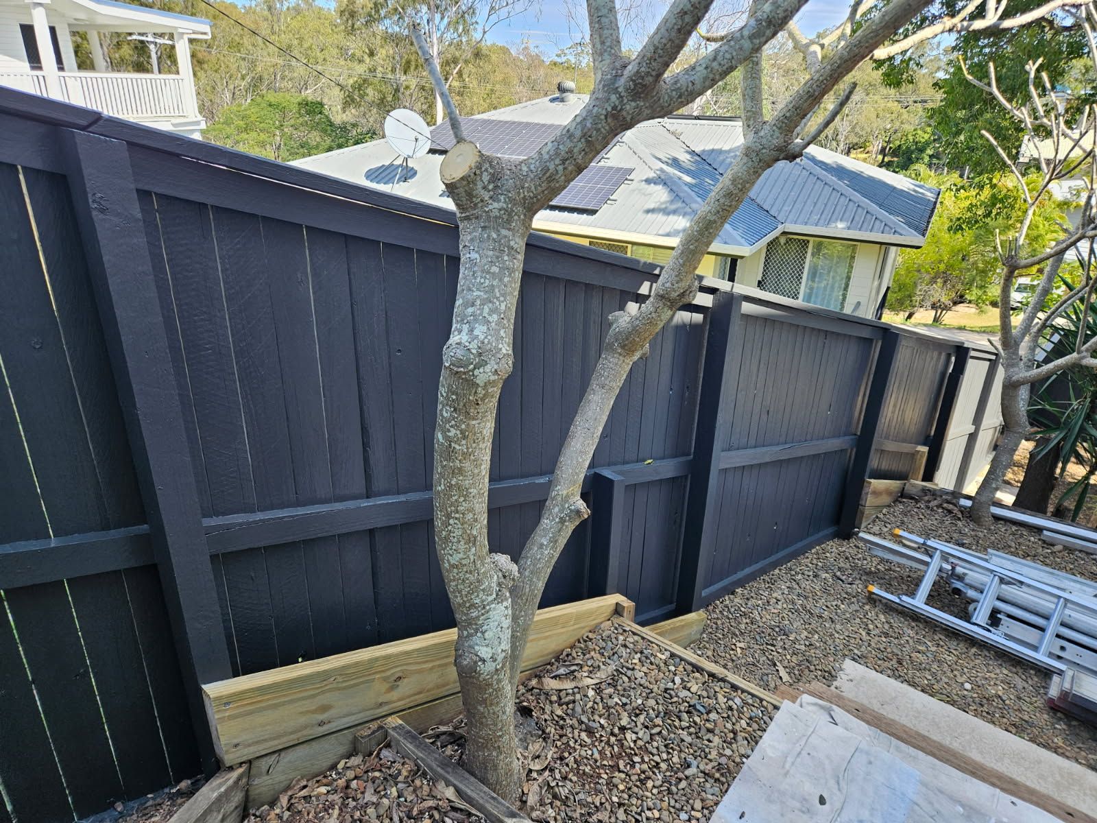 A Dark-painted Wooden Fence Borders a Garden Area — Priority Painters in Gladstone Central, QLD