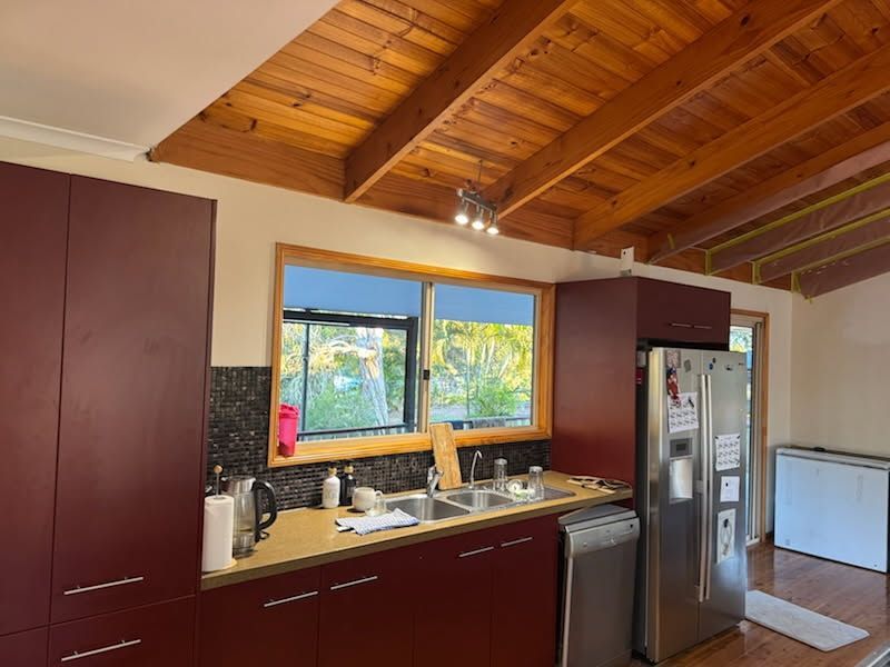 A Kitchen With Burgundy Cabinets, and Stainless Steel Appliances — Priority Painters in Gladstone Central, QLD
