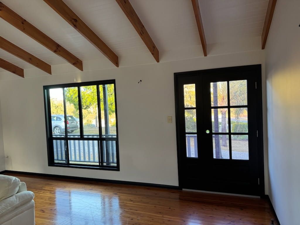 A Bright Room With Polished Wood Floors, White Walls — Priority Painters in Gladstone Central, QLD