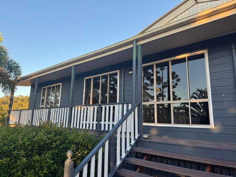 A Single-story, Dark Blue House With White Porch Railings — Priority Painters in Gladstone Central, QLD