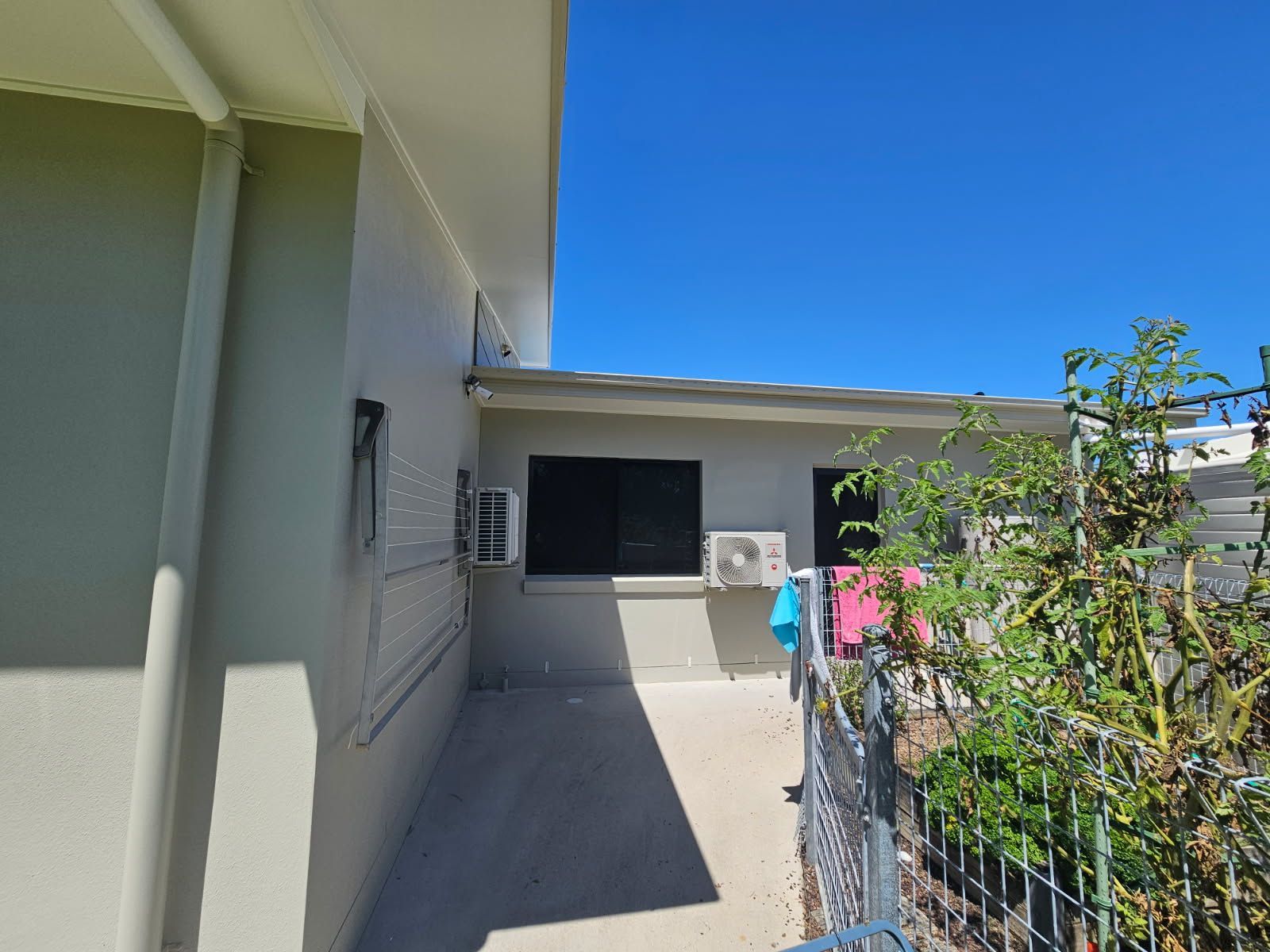 A Light-colored House Exterior Features a Concrete Patio Area — Priority Painters in Gladstone Central, QLD