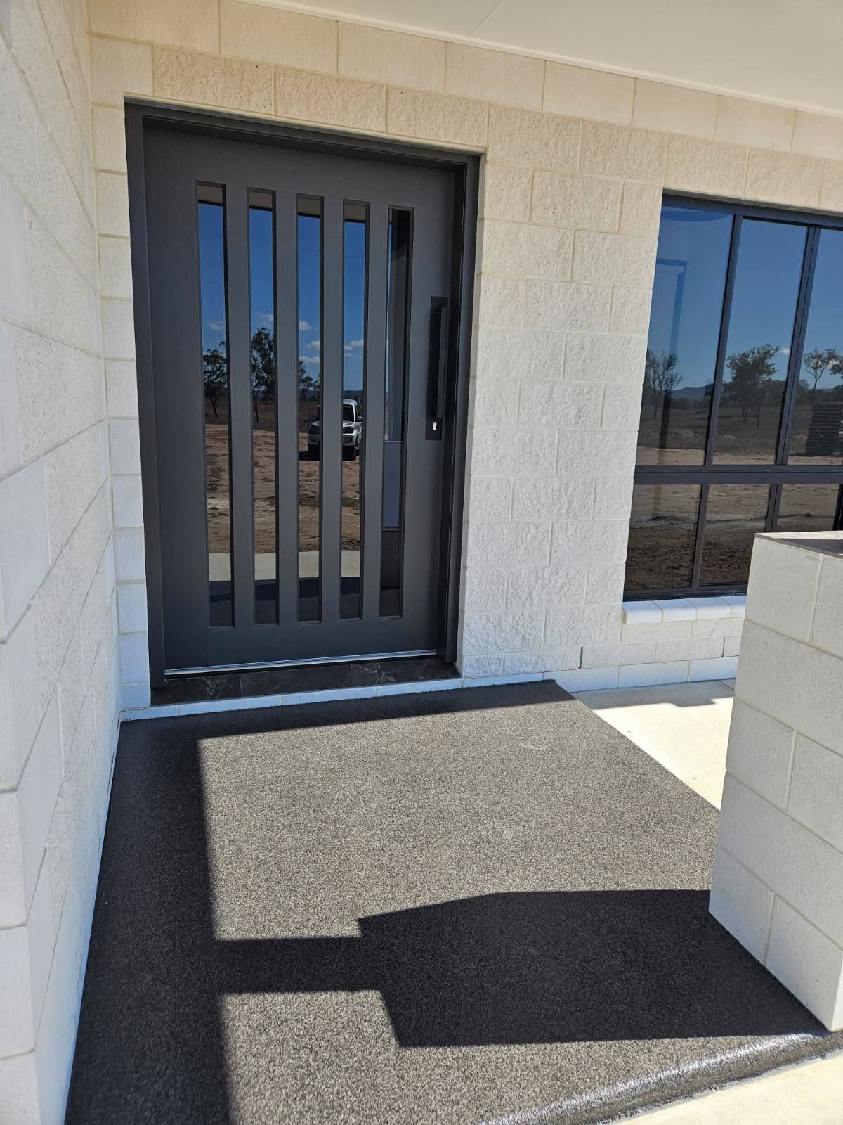 A Modern Entryway With a Dark Grey Door Featuring Vertical Glass Panels — Priority Painters in Gladstone Central, QLD