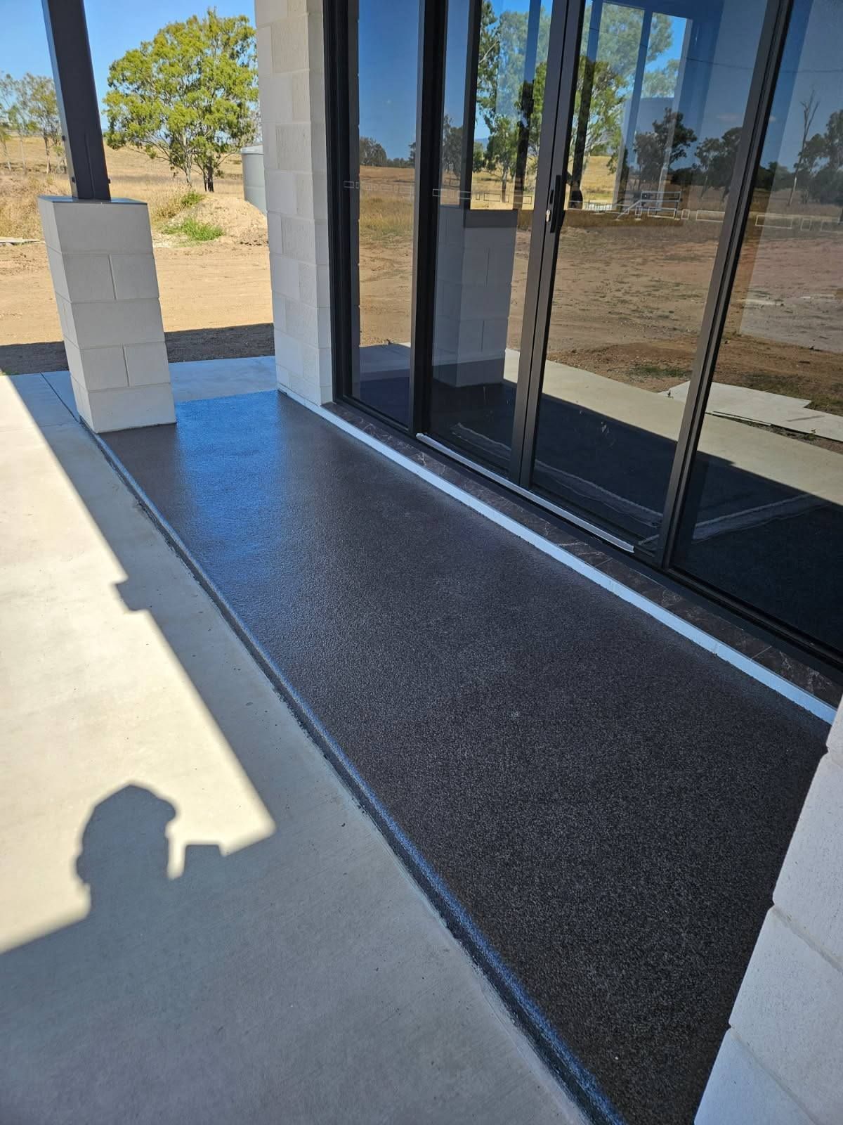 Textured Patio Surface Installed Directly in Front of Glass Sliding Doors — Priority Painters in Gladstone Central, QLD