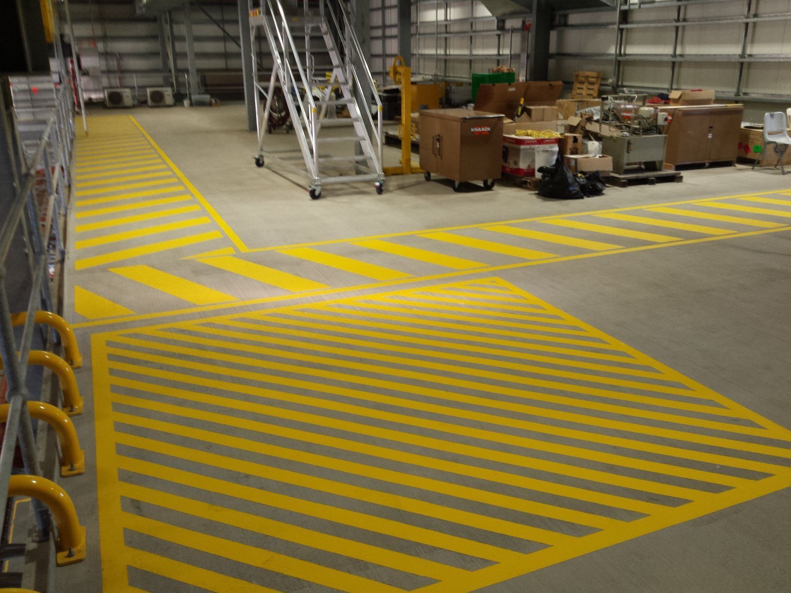Warehouse Floor Featuring Painted Yellow and Grey Striped — Priority Painters in Gladstone Central, QLD