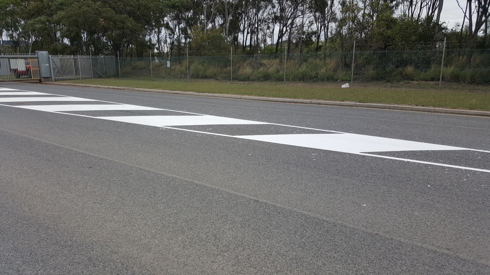 A Series of White Slanted Road Markings Painted on Grey Asphalt — Priority Painters in Gladstone Central, QLD
