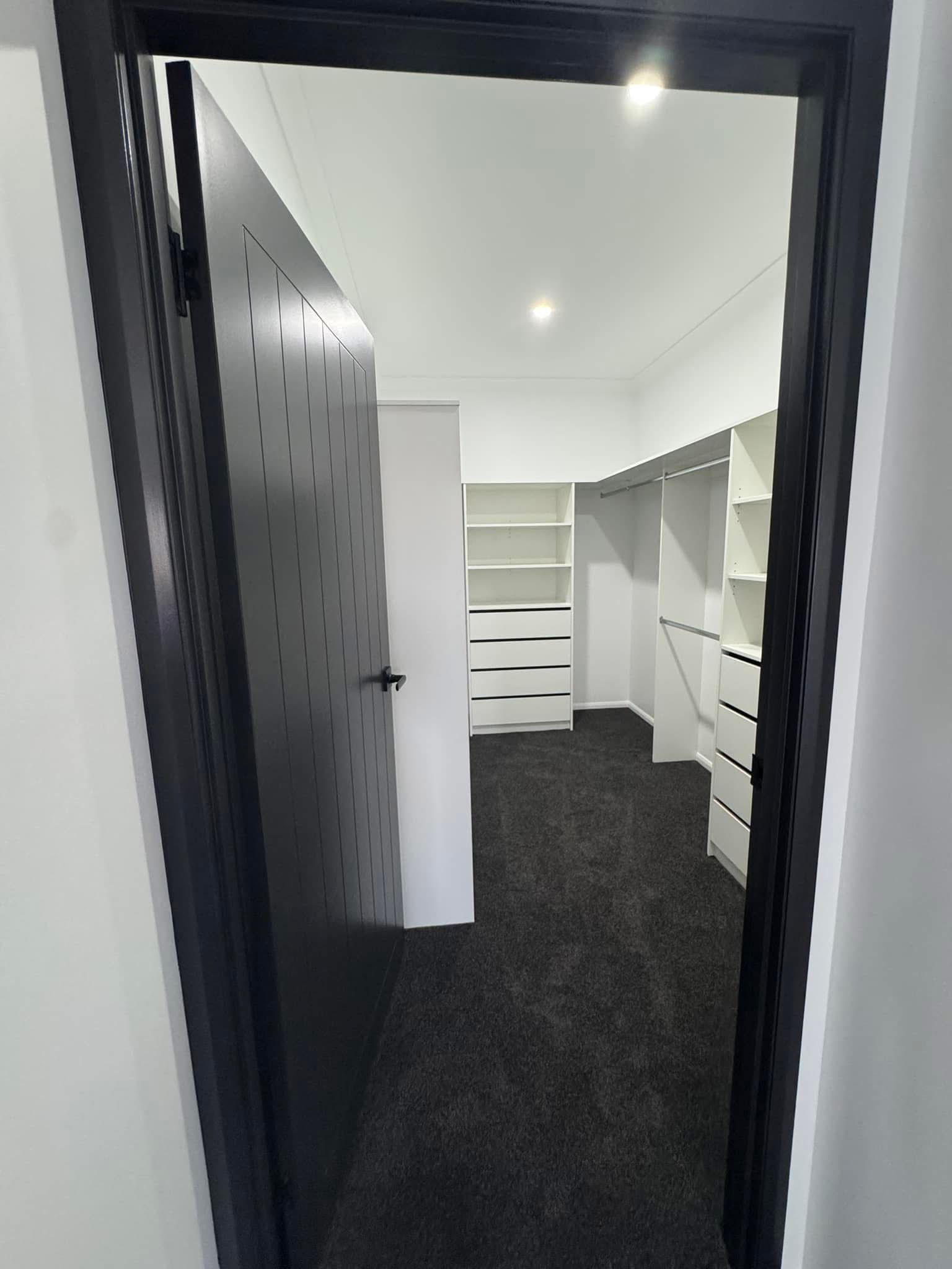 A Doorway Leading Into a Walk-in Closet Featuring White Shelves — Priority Painters in Gladstone Central, QLD
