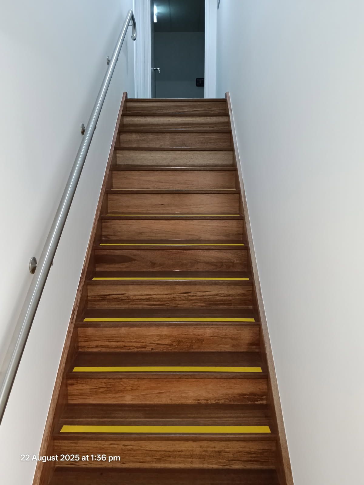 A Straight Wooden Staircase With Yellow Non-slip Strips — Priority Painters in Gladstone Central, QLD