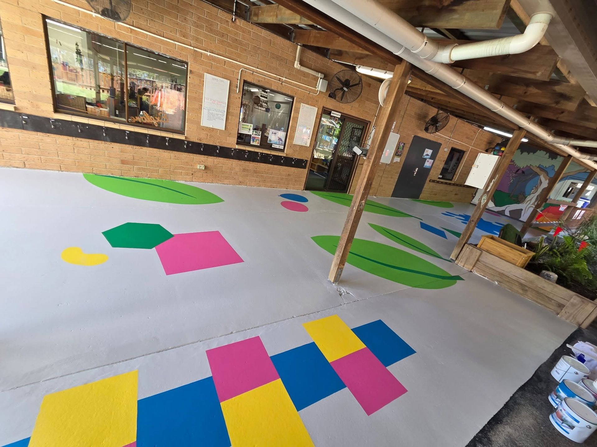 A Grey Outdoor Floor Painted With Colorful Geometric Shapes — Priority Painters in Gladstone Central, QLD
