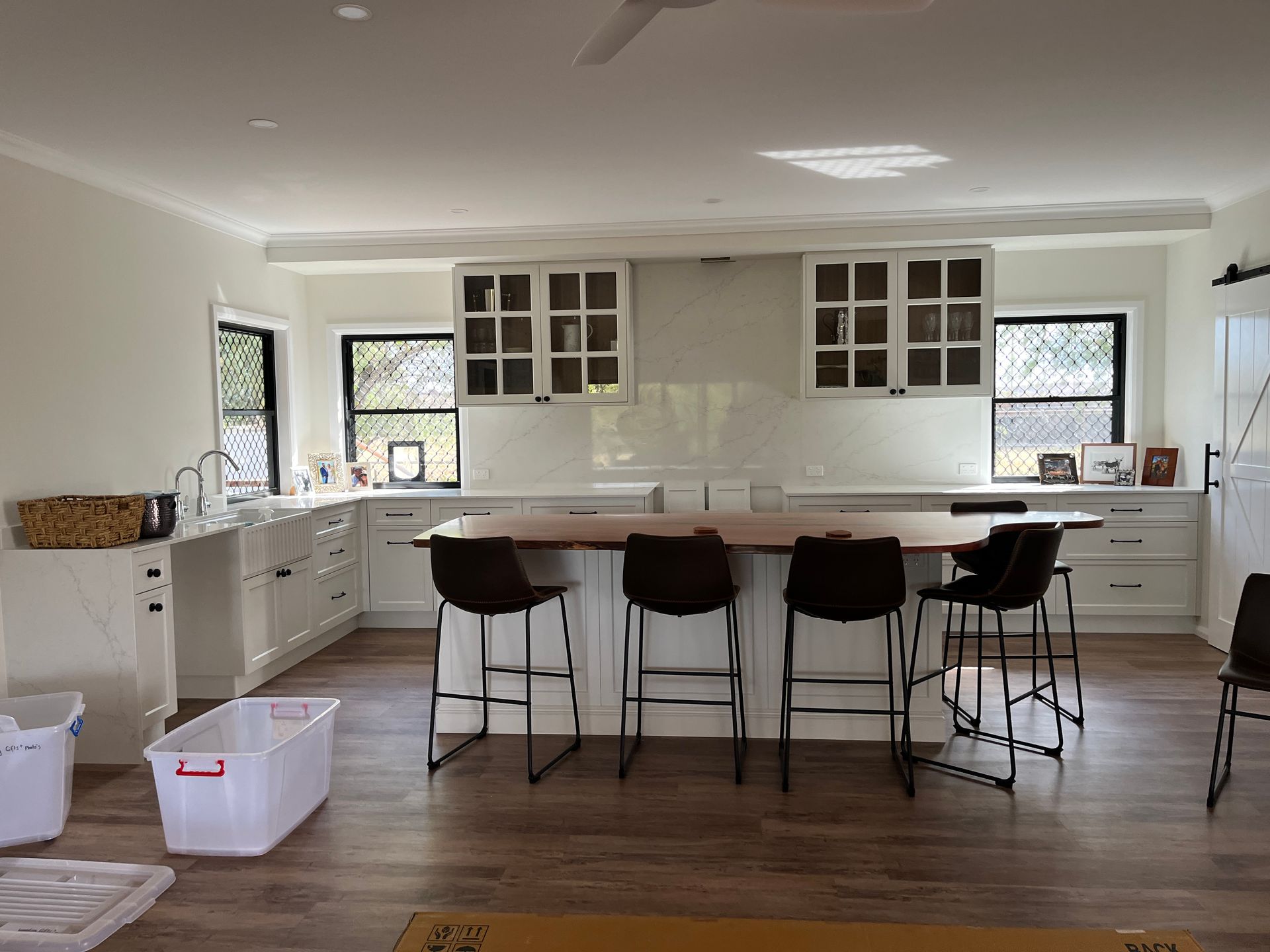 A Modern Kitchen Featuring White Cabinets, a Wooden Island — Priority Painters in Gladstone Central, QLD
