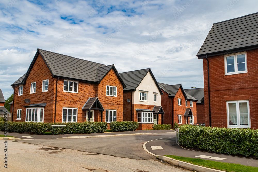Row of brick houses with gray roofs on a residential street.