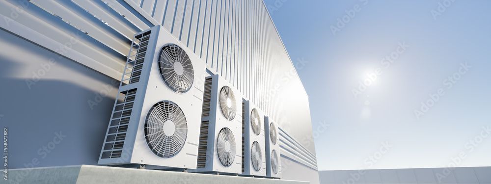 Air conditioning units on a building wall against a bright blue sky.