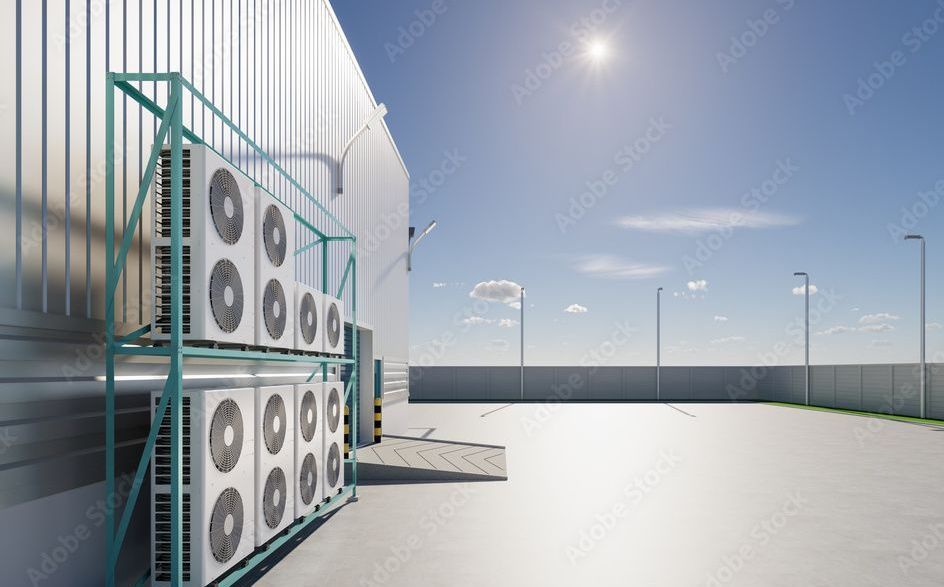 Air conditioning units on a rack outside a building on a sunny day.