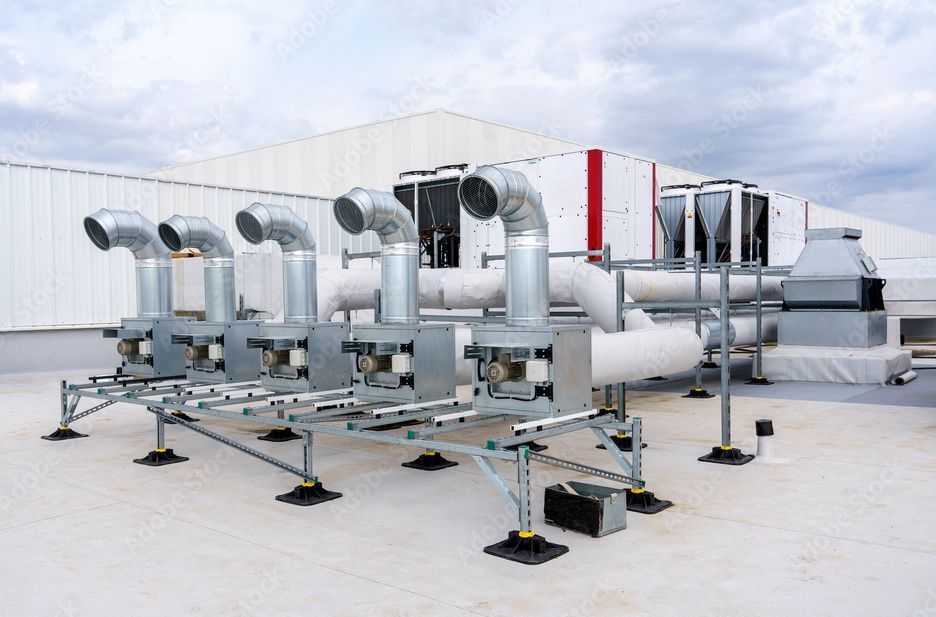 HVAC equipment on a white rooftop. Silver ducts, piping, and mechanical units.