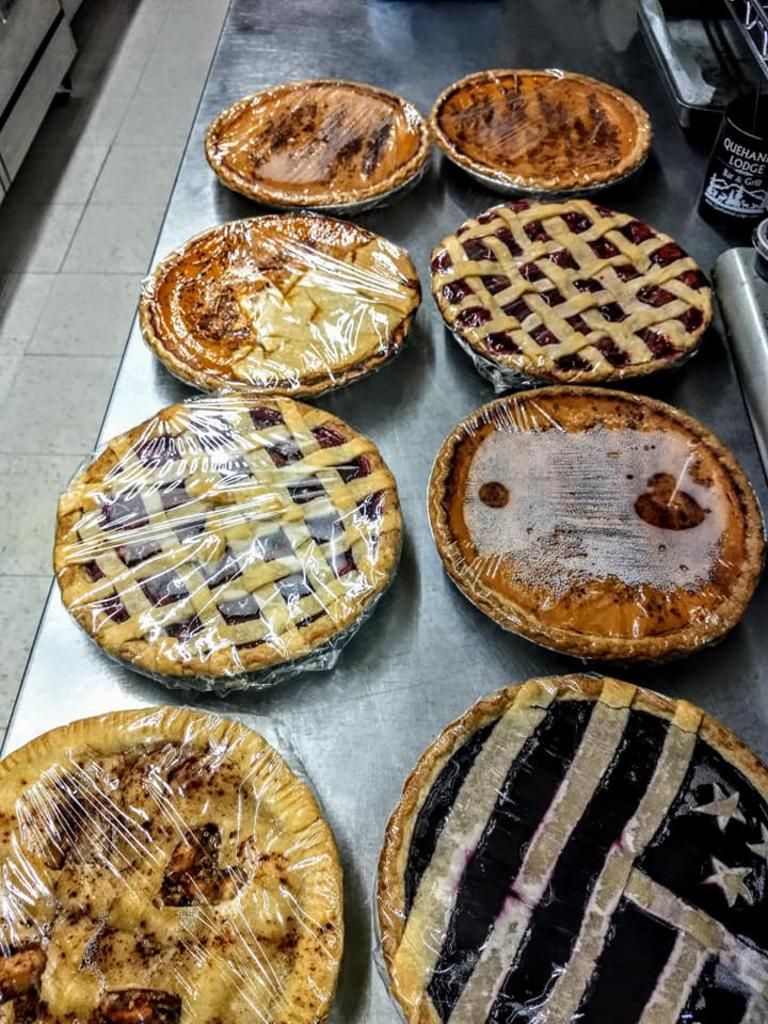 a variety of pies are wrapped in plastic on a table