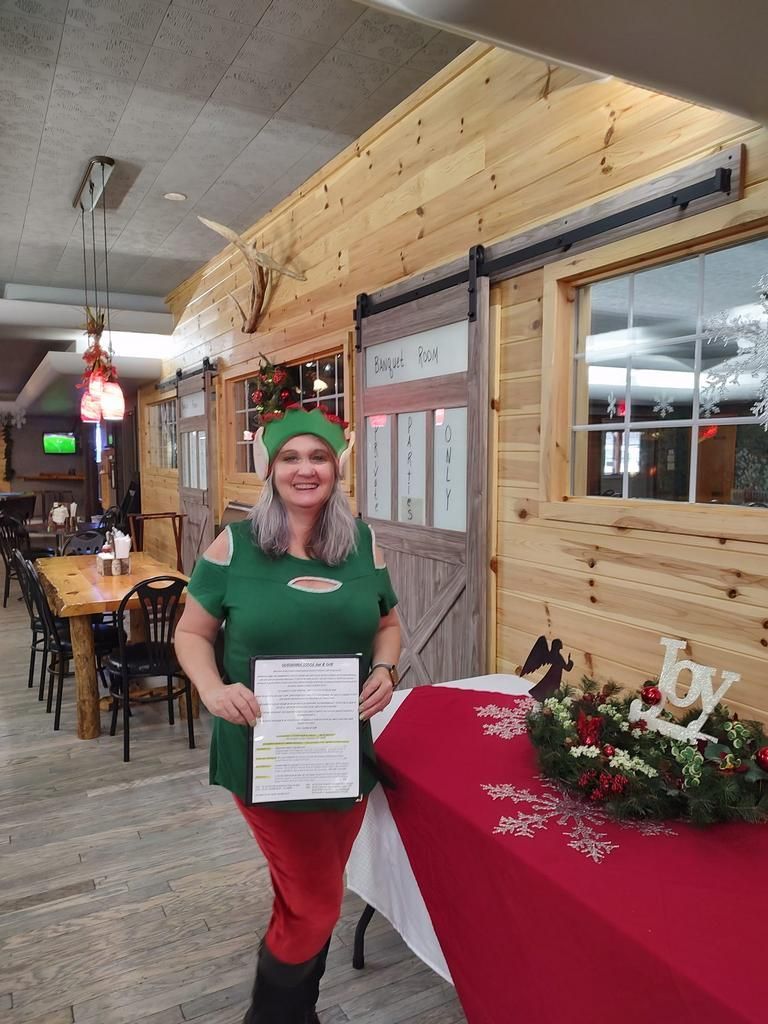 a woman in an elf costume stands in front of a banquet room