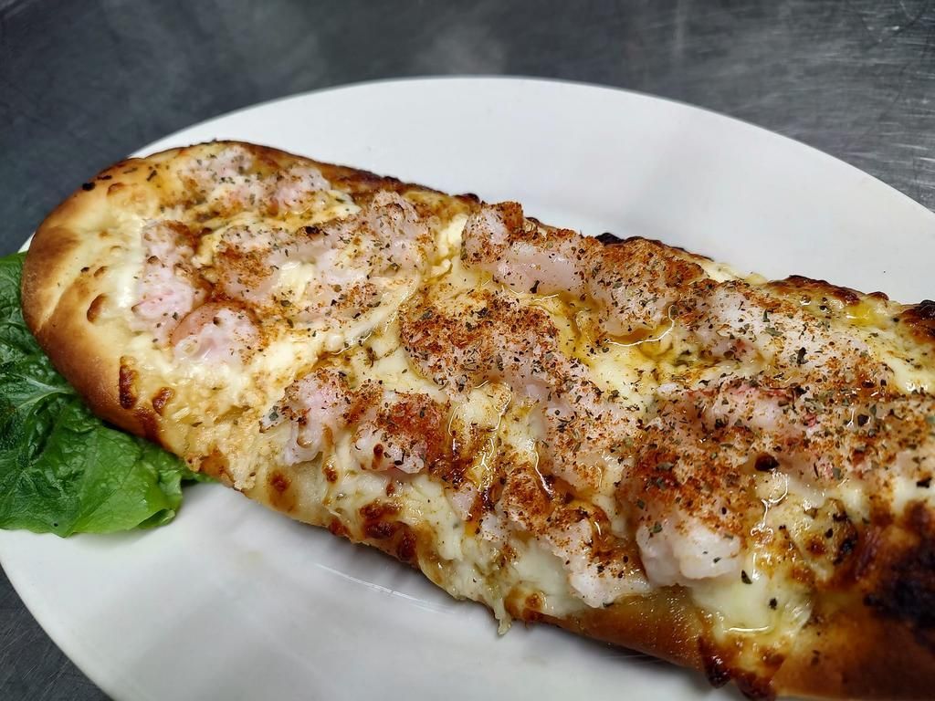 a pizza with shrimp and cheese on a white plate