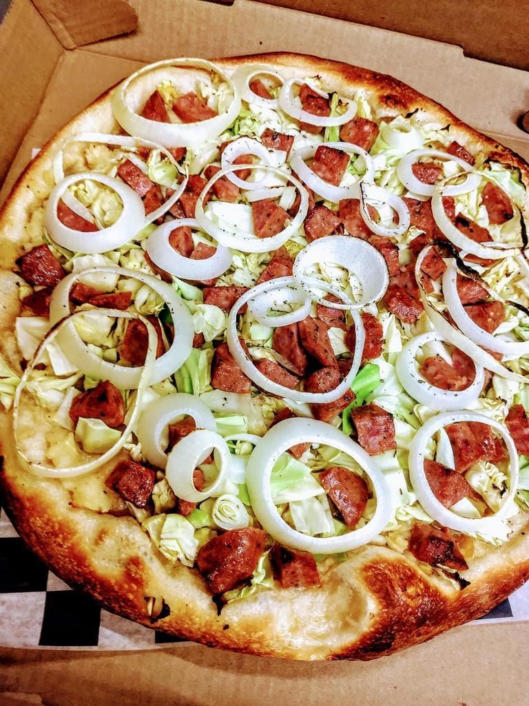 a pizza with sausage cabbage and onions on it