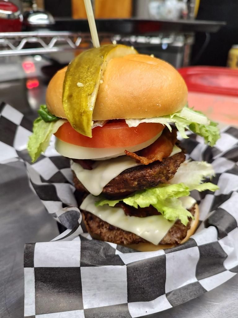 a hamburger with a pickle on top of it