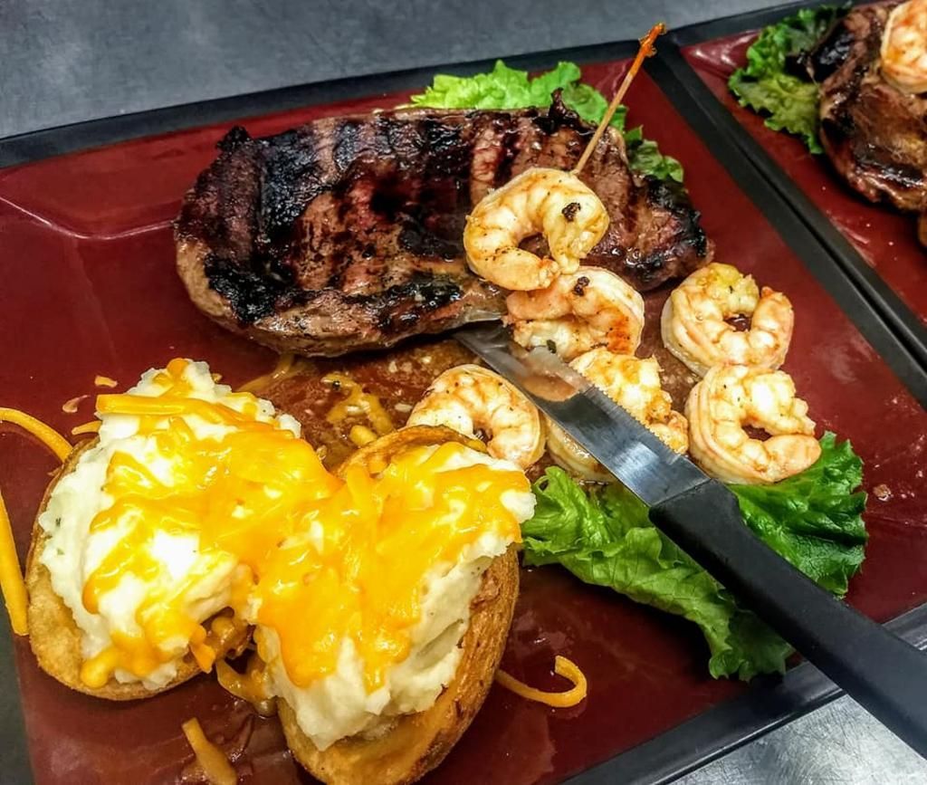 a plate of food with a steak and shrimp on it