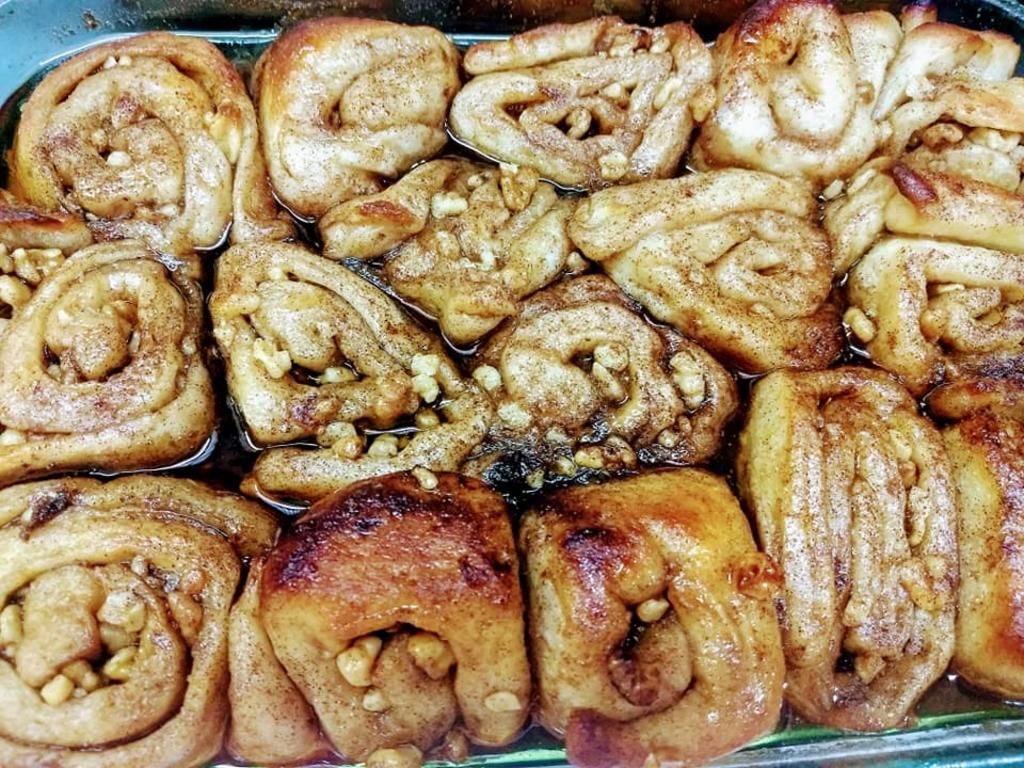 a bunch of cinnamon rolls are sitting in a pan