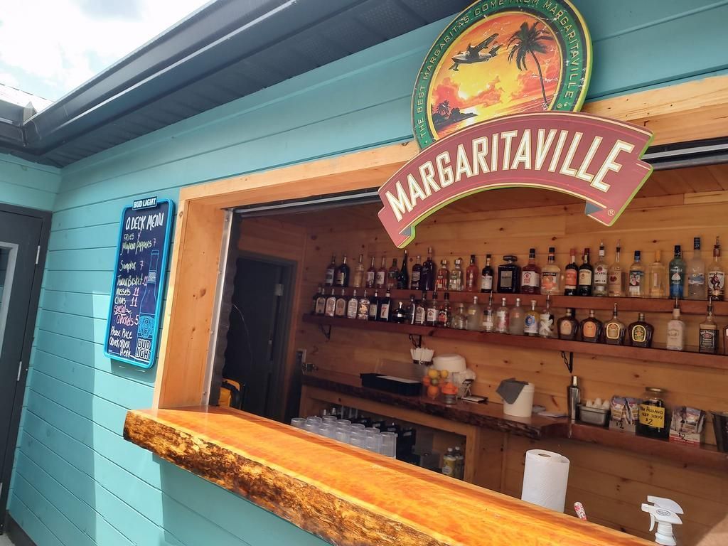 a margaritaville sign hangs above a bar