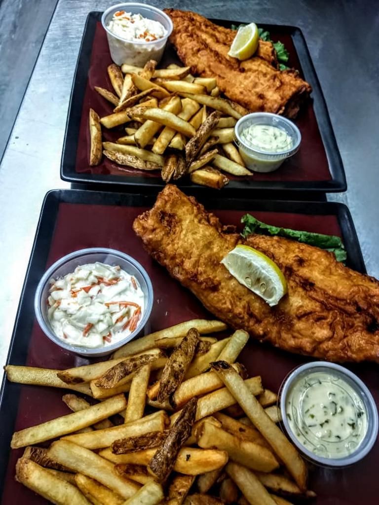 two trays of fish and french fries with coleslaw and tartar sauce
