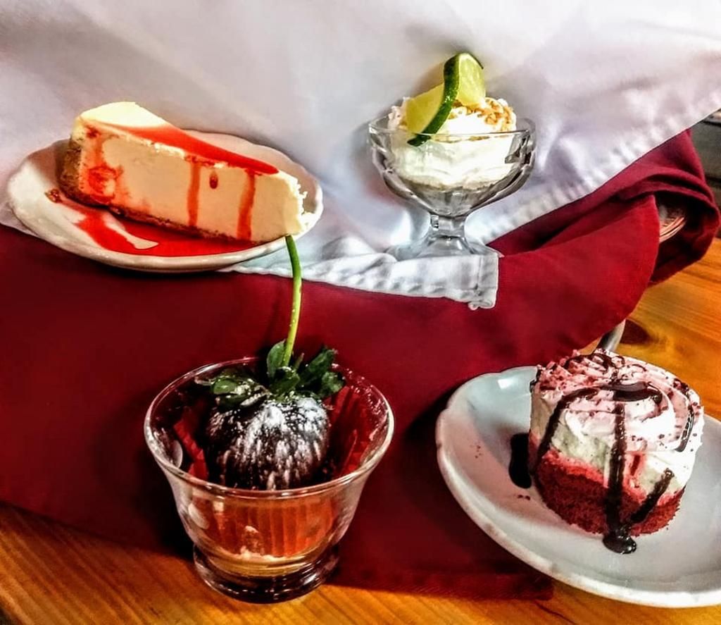 three desserts are on a table including a cheesecake
