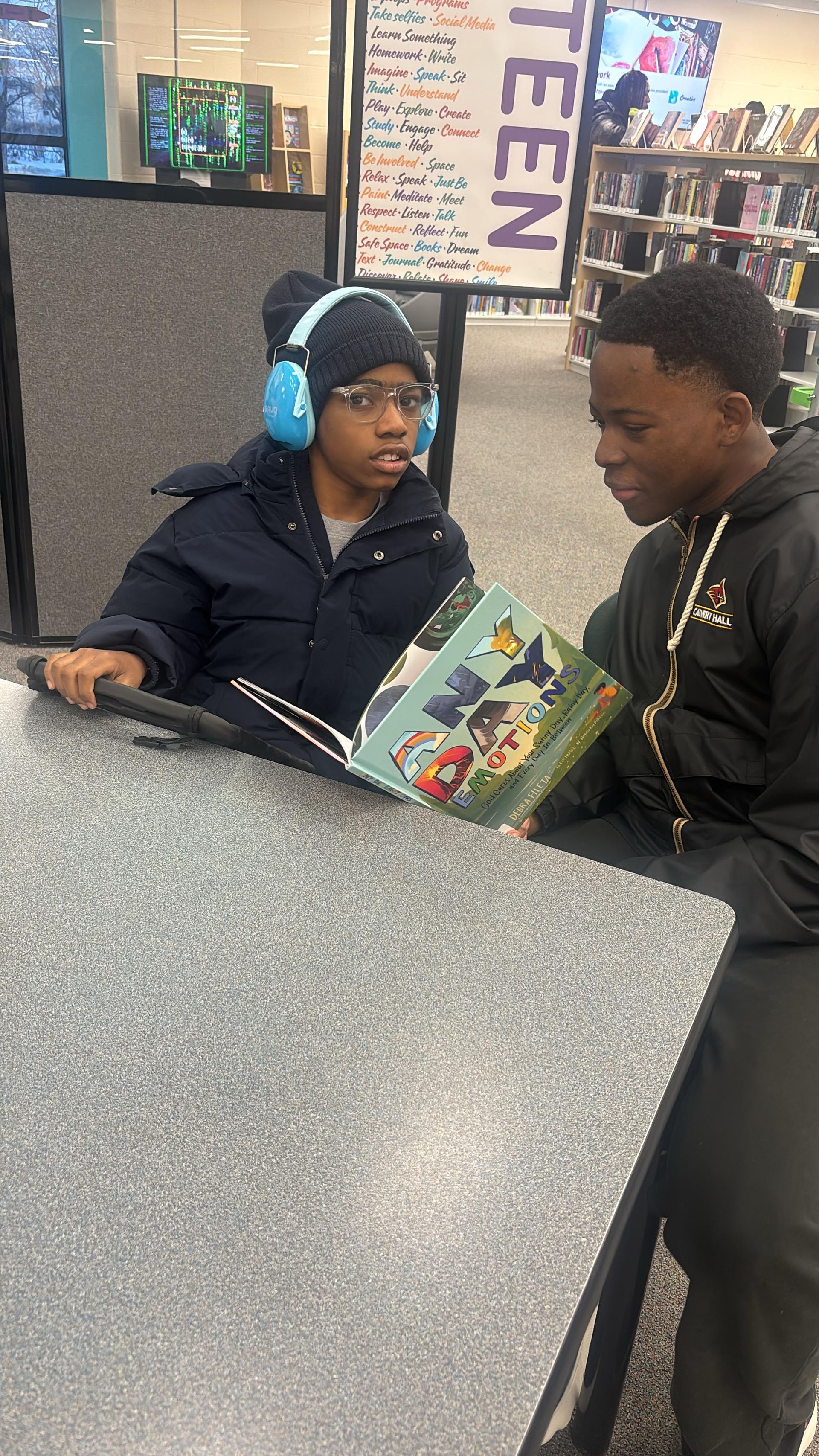 Two people looking at an illustrated book. 