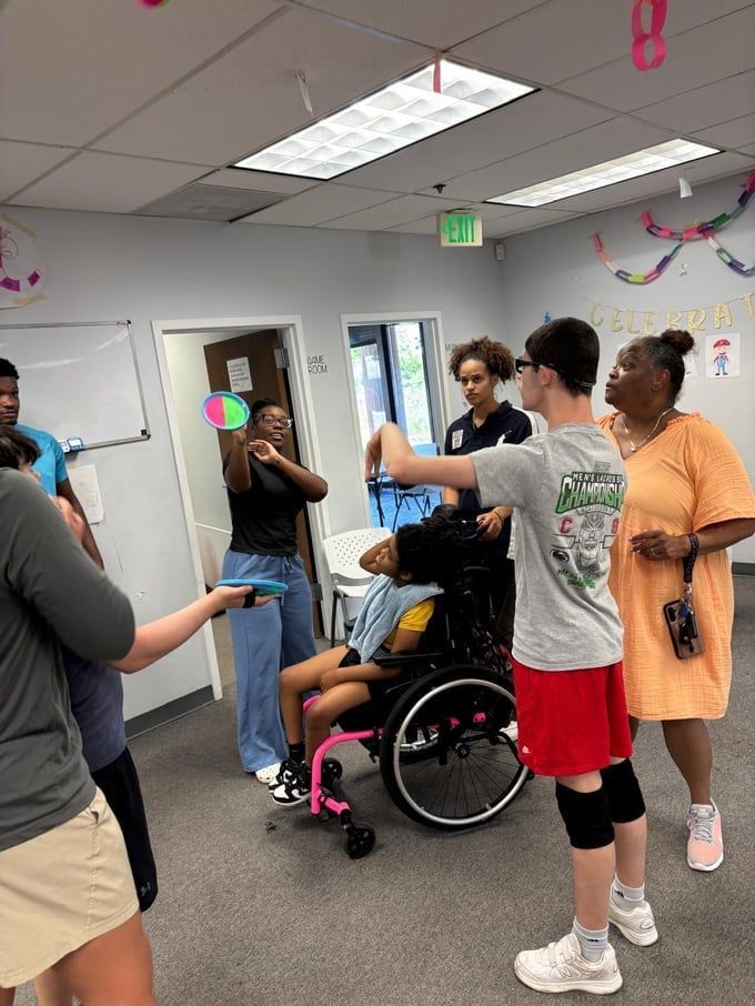 Group plays with a colorful ball in a room.
