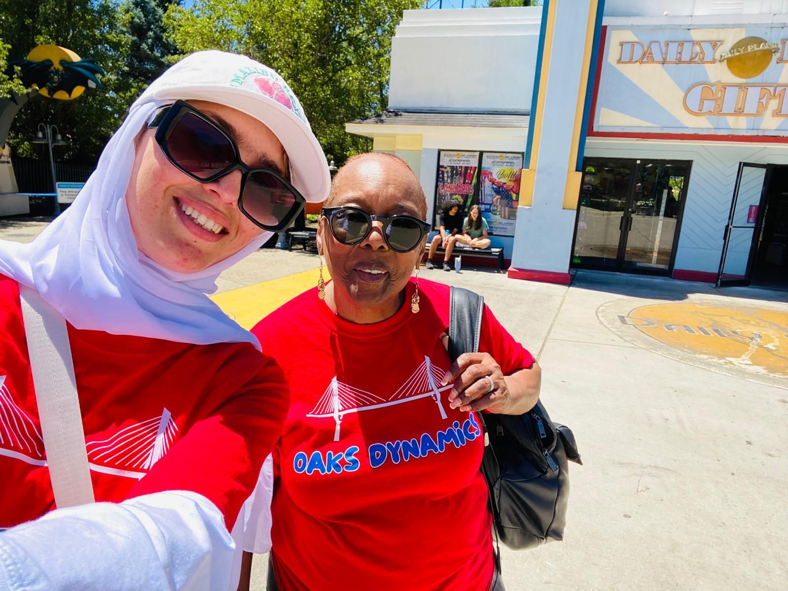 Two people smile for a selfie outdoors. 