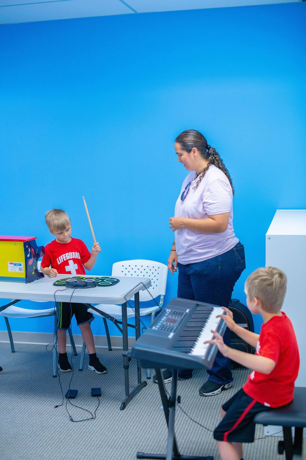 Two boys and an instructor in a music class. 