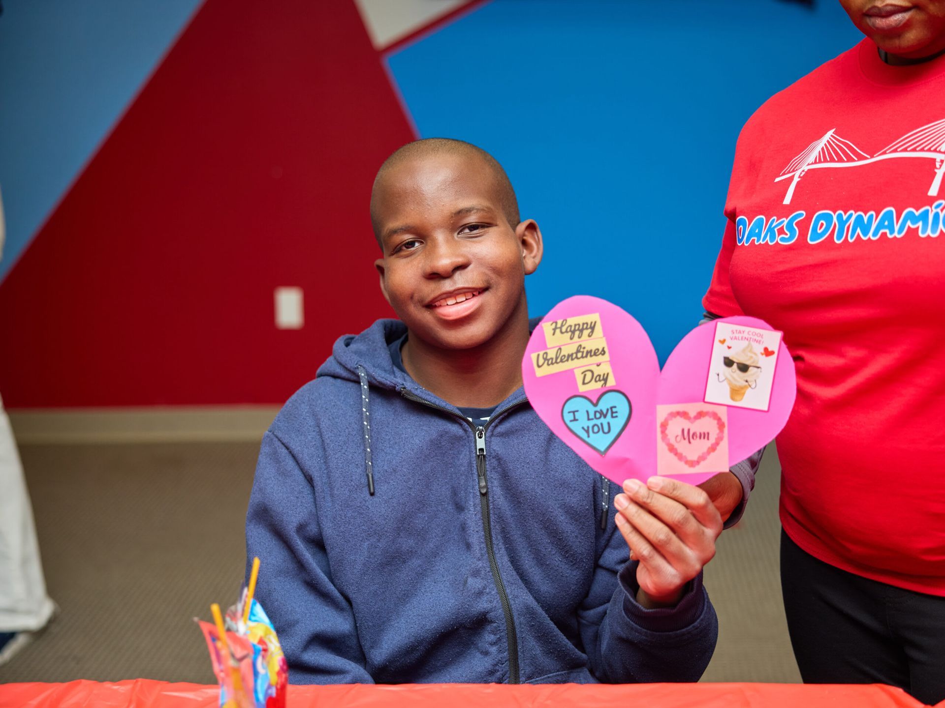 A person holding a Valentine's Day card, smiling. 