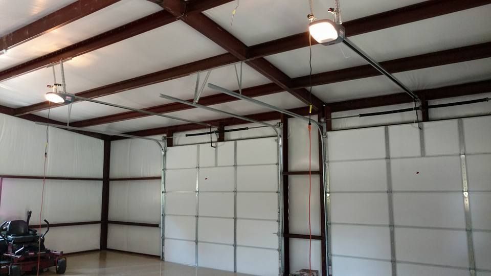 Interior of a metal-framed garage with white insulated doors and exposed ceiling beams