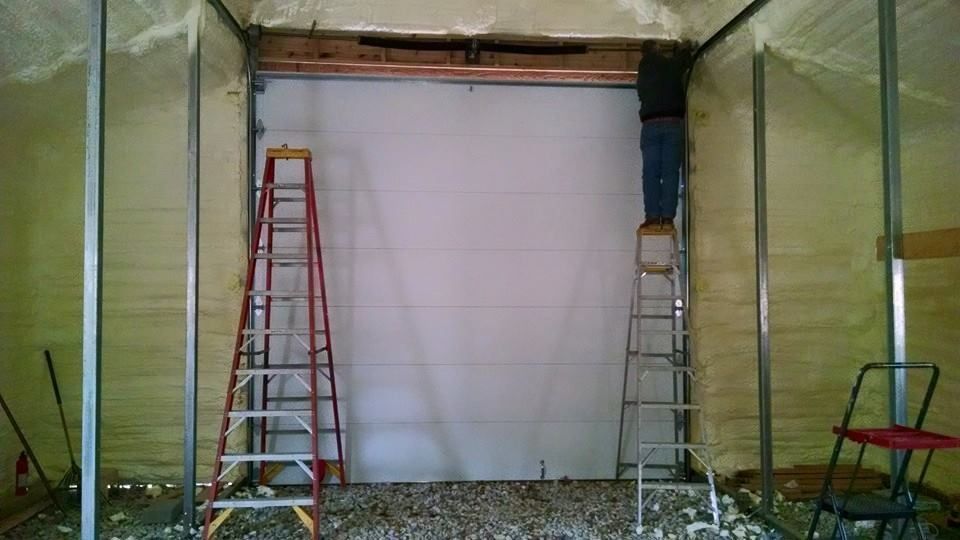 Partially finished interior wall with two ladders and exposed framing on a gravel floor