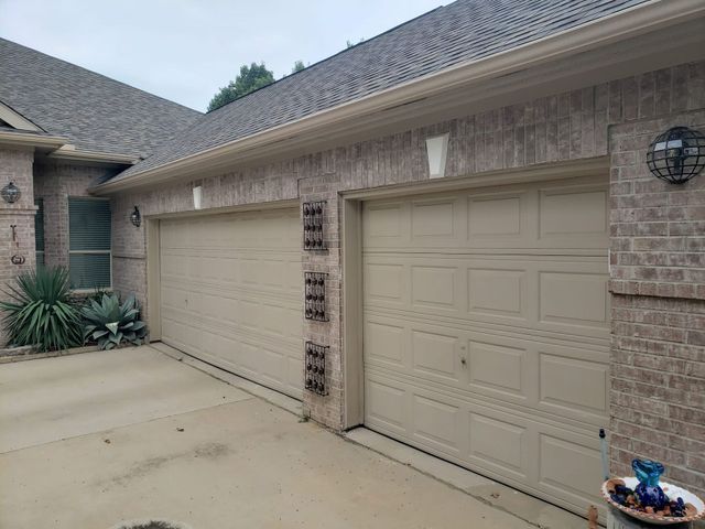Exterior of a beige stucco house with a two-car garage and driveway