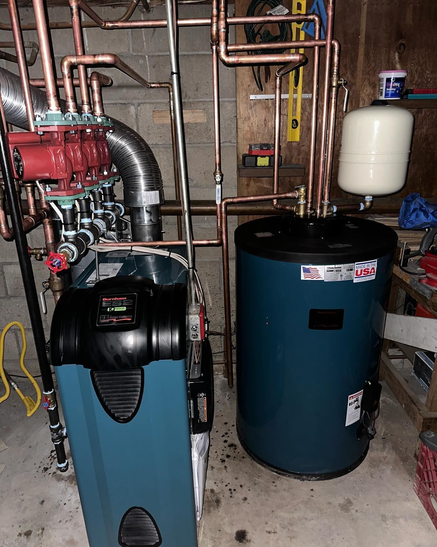 Basement HVAC and water heater with metal ductwork and pipes in a utility room.